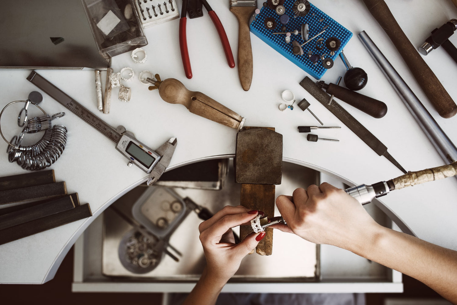 Female working on a cluttered workbench, crafting accessories and gadgets using various tools.