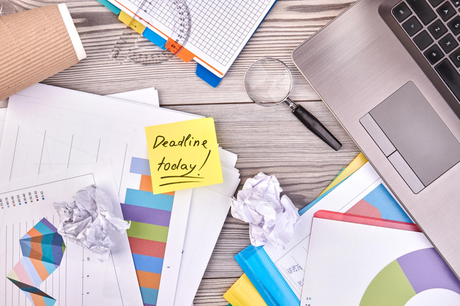 Office supplies on a white wooden desk with a "deadline today" concept.