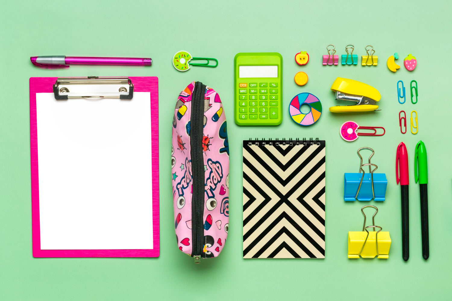 Office supplies on a desk - paper clips, scissors, pens, felt-tip pens, sharpener, backpack, calculator.