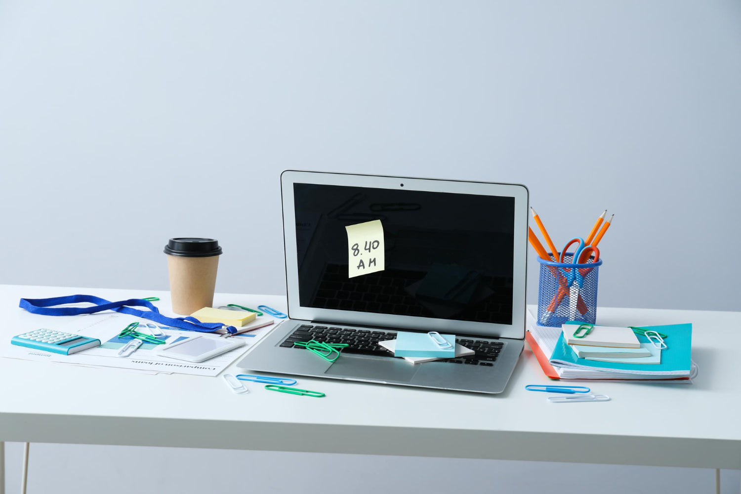 Cluttered office desk with scattered papers, stationery, and computer equipment, depicting the need for organization in a workspace.