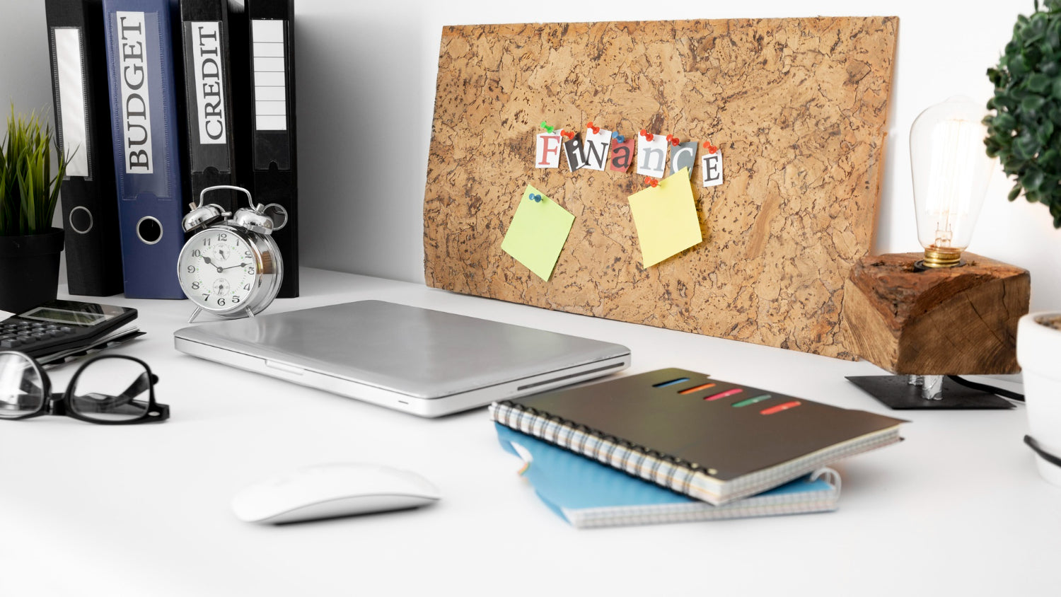 Office desk surface with notebooks and laptop.