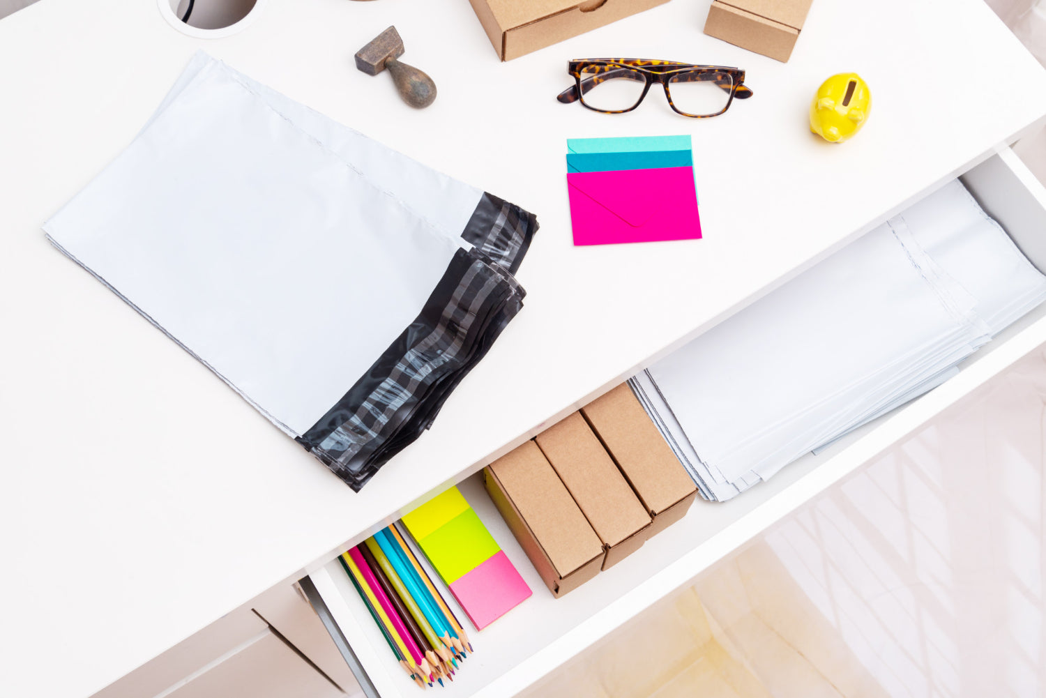 Top view of an organized office desk with post envelopes and stationery.