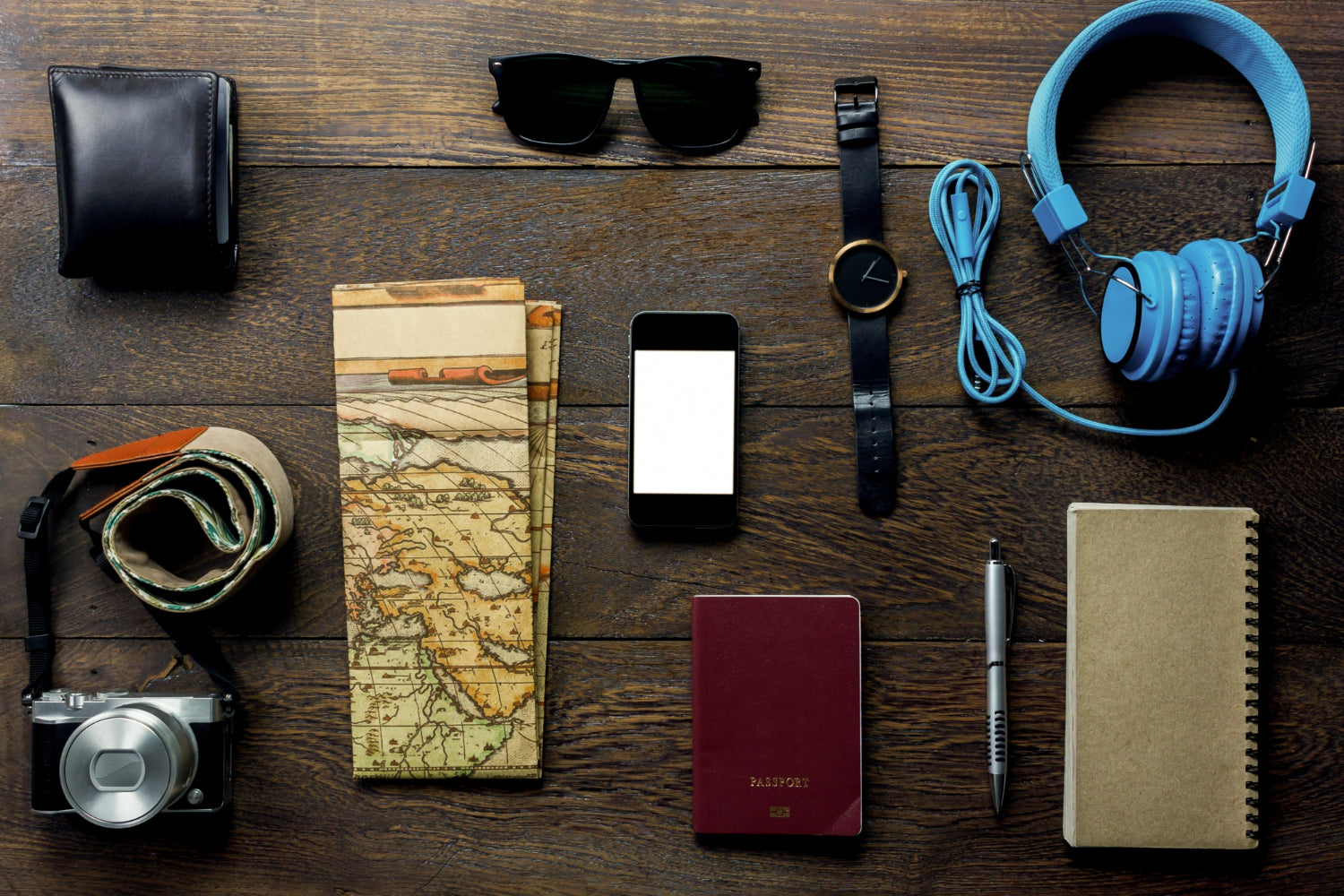 top-view-accessories-travel-with-mobile-phone-passport-camera-headphones-wallet-notepaper-map-watch-table-wooden-with-copy-space-travel-concept