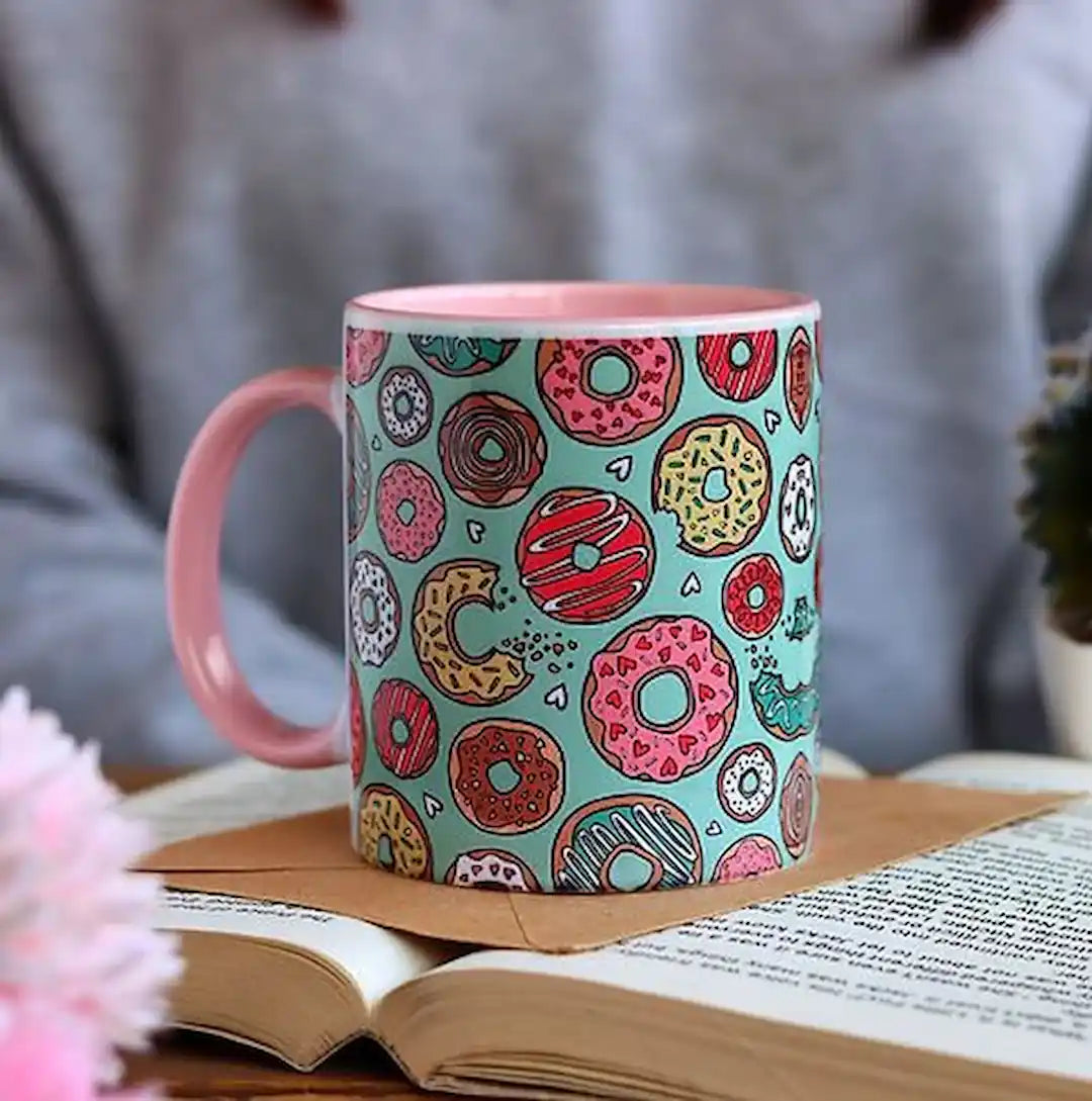 Graphic mug featuring doughnuts design.